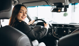 Young woman testing a car in a car showroom